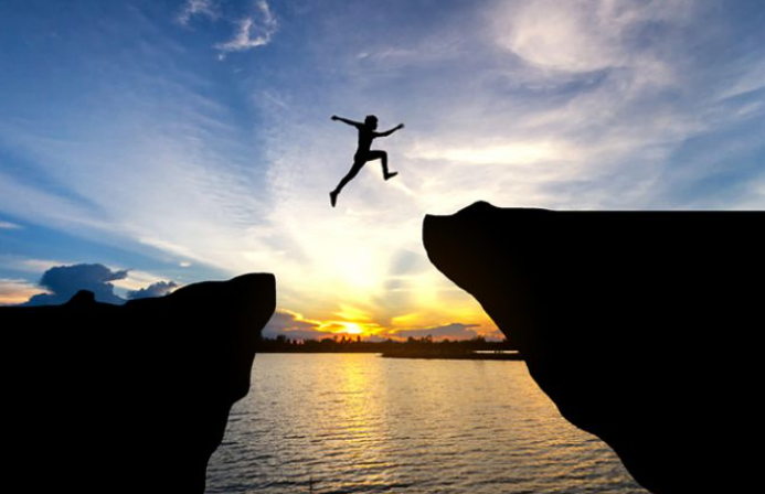 A person jumping off a cliff into the water